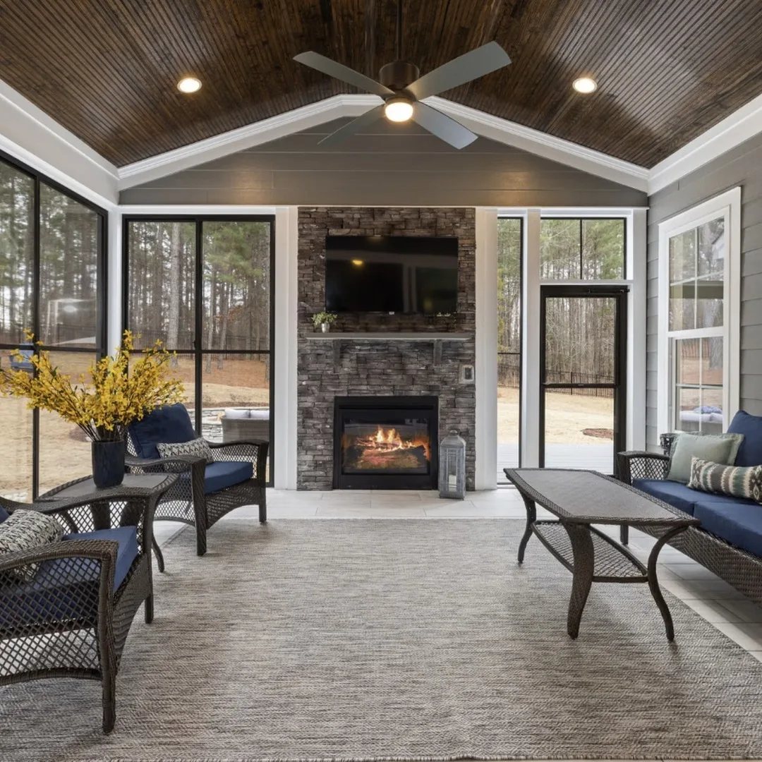 Finished sunroom with stacked-stone fireplace and tongue-and-groove wood ceiling